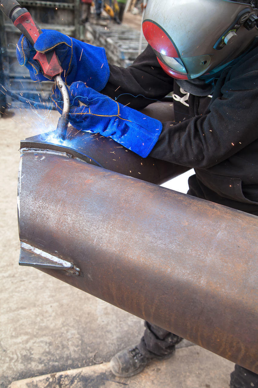 MAN WORKING ON METAL IN CONTAINER