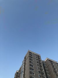 Low angle view of buildings against clear blue sky