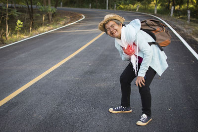 Side view of senior woman standing on road