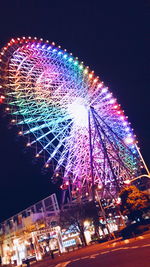 Low angle view of ferris wheel at night