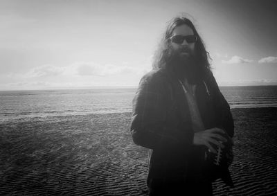 Portrait of man with beard standing at beach