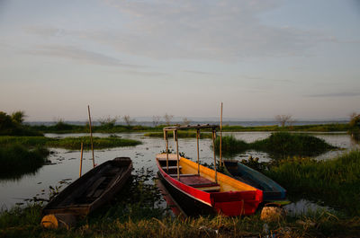 Boats moored in lake against sky