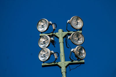 Low angle view of electric lamp against blue sky