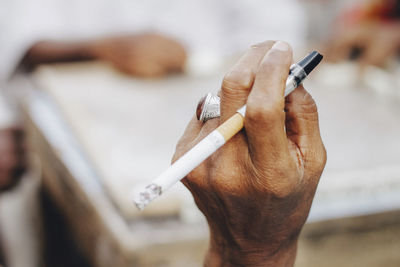 Close-up of hand holding cigarette