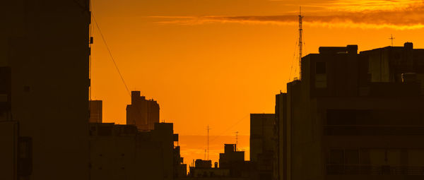 Silhouette buildings against sky during sunset