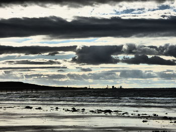 Scenic view of calm sea against cloudy sky