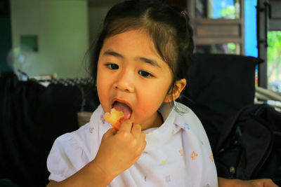 Close-up of girl eating food at home