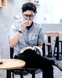 Young man sitting on chair at table