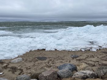 Scenic view of rocks on beach against sky