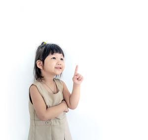 Portrait of a smiling girl standing against white background