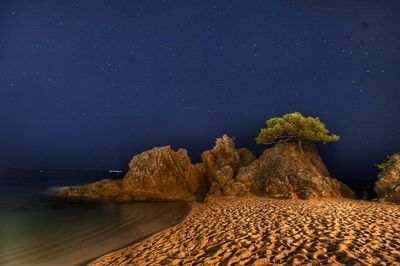 Scenic view of rock formation against sky at night