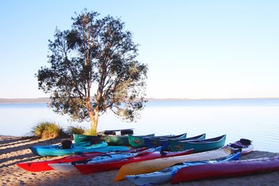 Lounge chairs on beach against clear sky