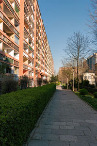 Footpath amidst buildings against sky