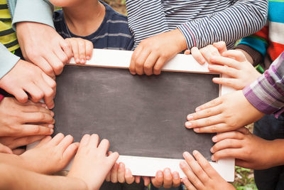 High angle view of kids holding writing slate