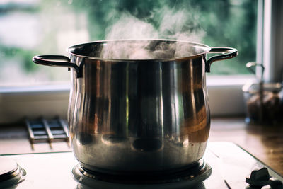 Steaming pot cooking in the kitchen with window in background