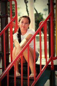 Portrait of girl sitting on stairs at playground