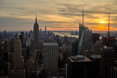 Modern buildings against sky during sunset