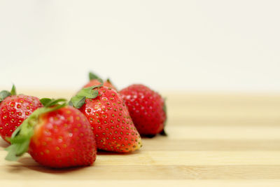 Close-up of strawberries on table against white background