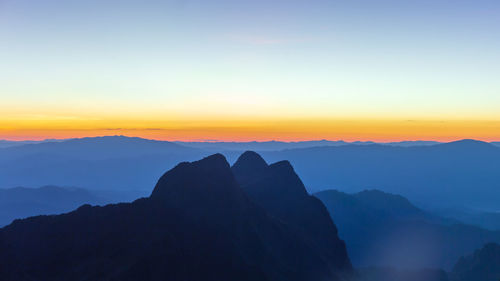 Scenic view of silhouette mountains against sky during sunset