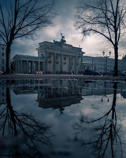 Reflection of building in lake against sky