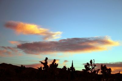 Silhouette of trees against cloudy sky