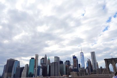 Modern buildings in city against cloudy sky