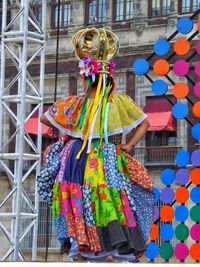 Person standing against multi colored umbrella