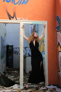 Full length of fashion model standing in abandoned building