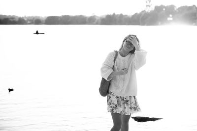 Woman standing by sea against sky