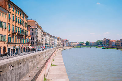 Canal amidst buildings in city against sky
