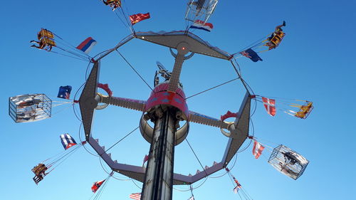 Low angle view of chain swing ride against clear sky