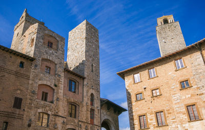 Low angle view of historic building against blue sky in the center of san gimignano, tuscany