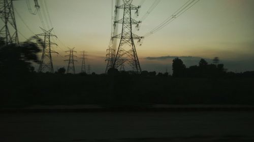 Silhouette of electricity pylon at sunset