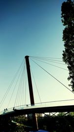 Low angle view of suspension bridge against blue sky