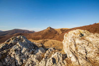 Panoramic view of rocky mountains against blue sky