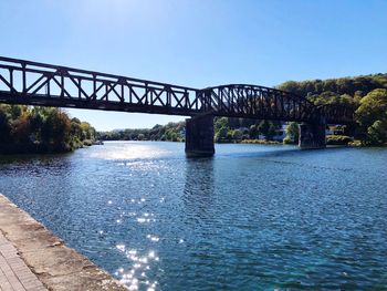 Bridge over river against clear blue sky