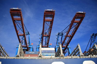 Low angle view of cranes against sky