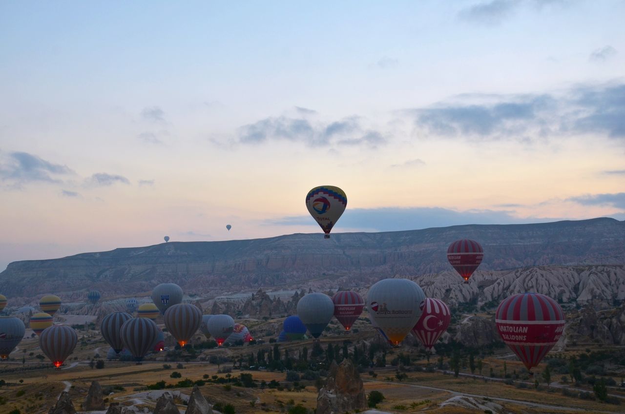 sky, landscape, sunset, scenics, tranquil scene, tranquility, hot air balloon, nature, beauty in nature, cloud - sky, mountain, outdoors, flying, cloud, no people, built structure, idyllic, dusk, horizon over land, non-urban scene