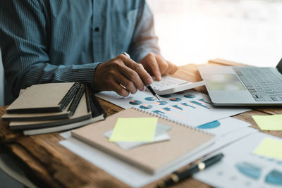 Midsection of business colleagues working on table