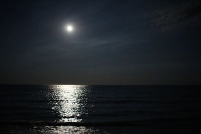 Scenic view of sea against moon in sky