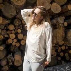 Young woman posing against logs