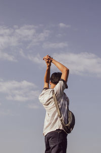 Rear view of man standing against sky