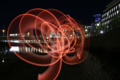 Reflection of illuminated ferris wheel in city at night