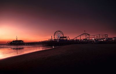 Illuminated ferris wheel at night from santa monica beach