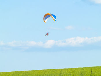 Low angle view of paragliding against sky