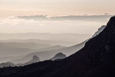 Scenic view of silhouette mountains against sky during sunset