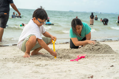 Children playing sand together. asian little kids playing at the beach.