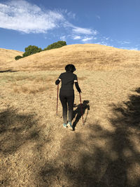 Rear view of hiker walking on grassy field at garin regional park