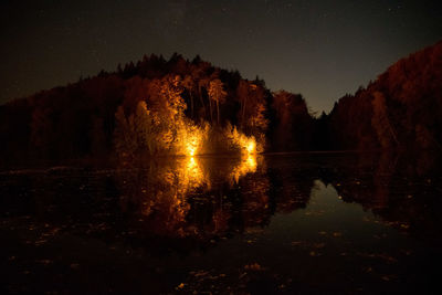 Scenic view of lake against sky at night