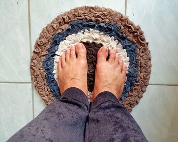 Low section of person standing on tiled floor